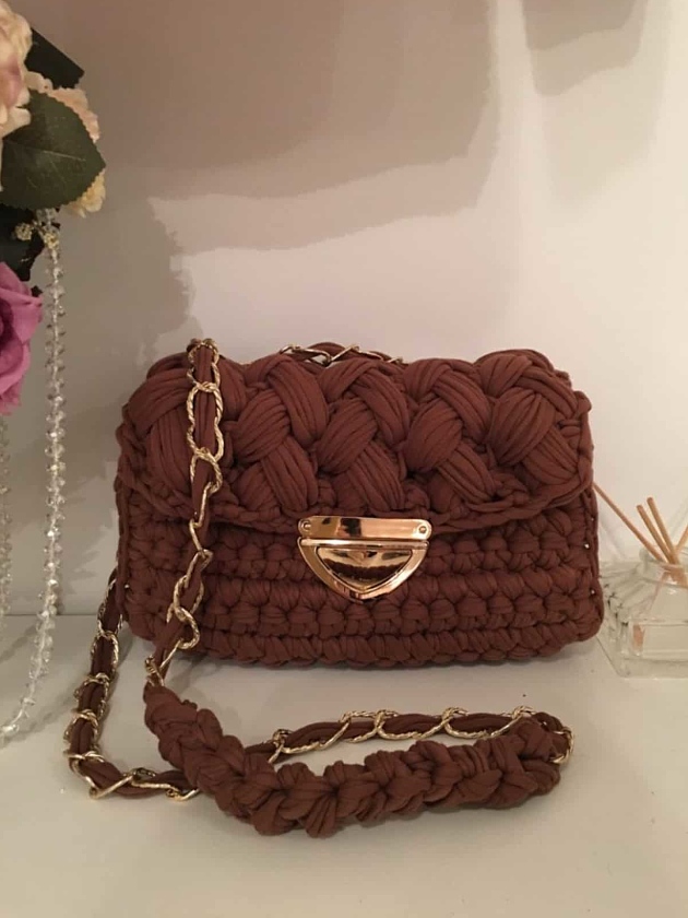 На фотографии коричневая вязаная сумка от Shapar, бренда женской одежды и аксессуаров ручной работы в интернет-магазине связанных спицами вещей.