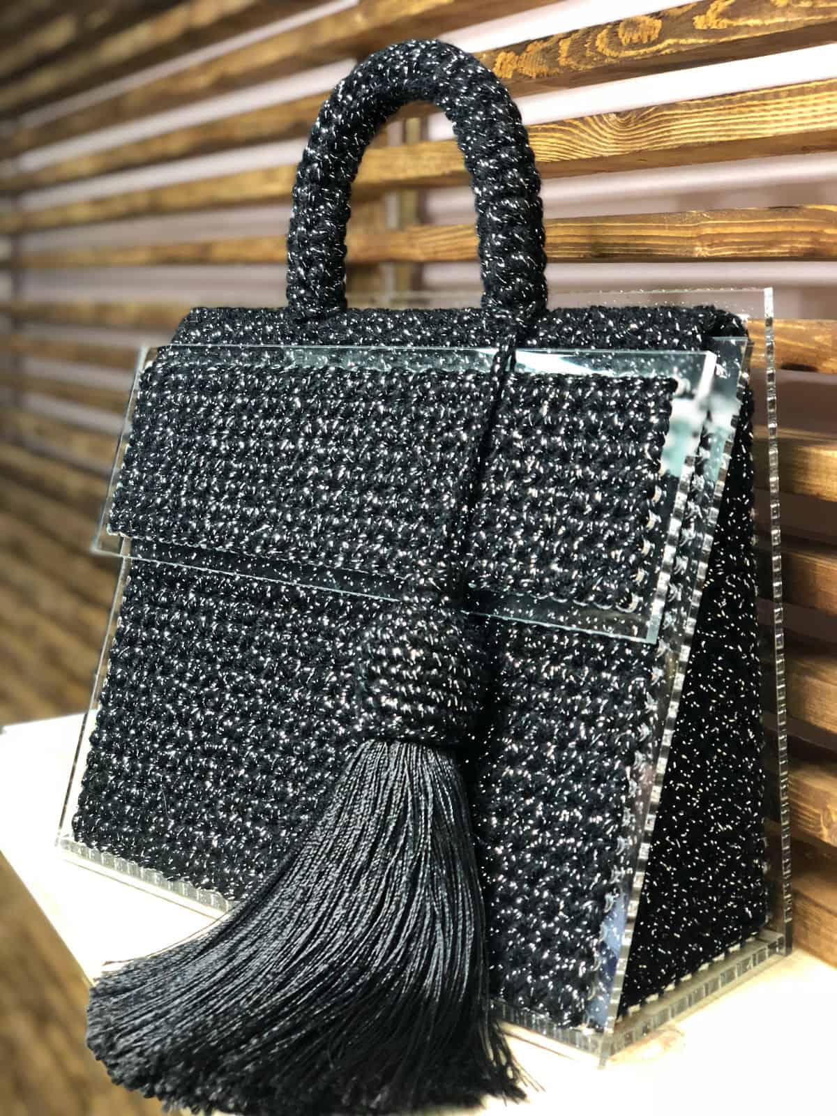 На фотографии женская сумка черного цвета от Shapar, бренда вязаных аксессуаров и одежды ручной работы в интернет-магазине связанных спицами вещей.