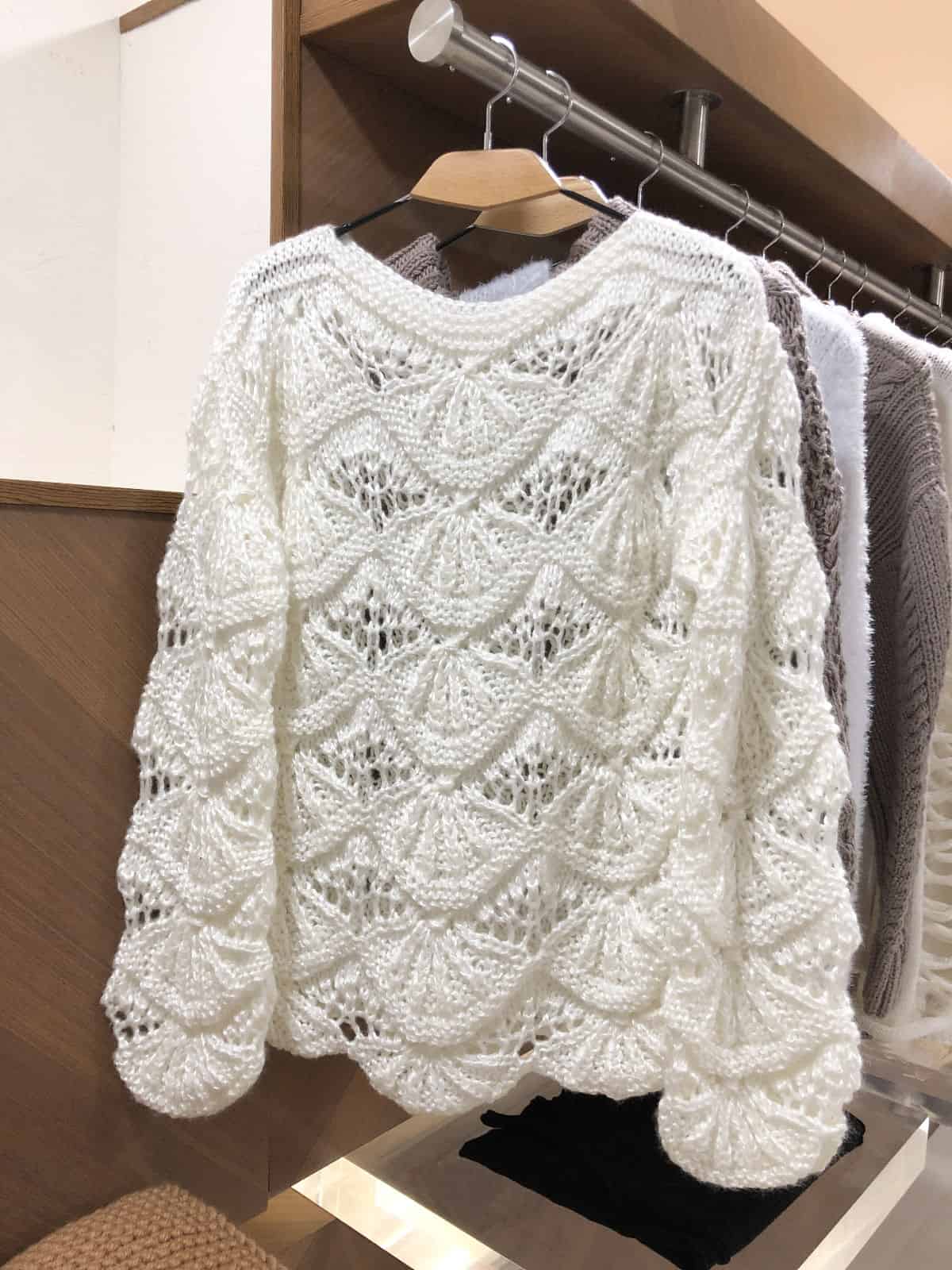 На шестой фотографии женский ажурный свитер на вешалке от Shapar, бренда вязаной одежды ручной работы в интернет-магазине связанных спицами вещей.