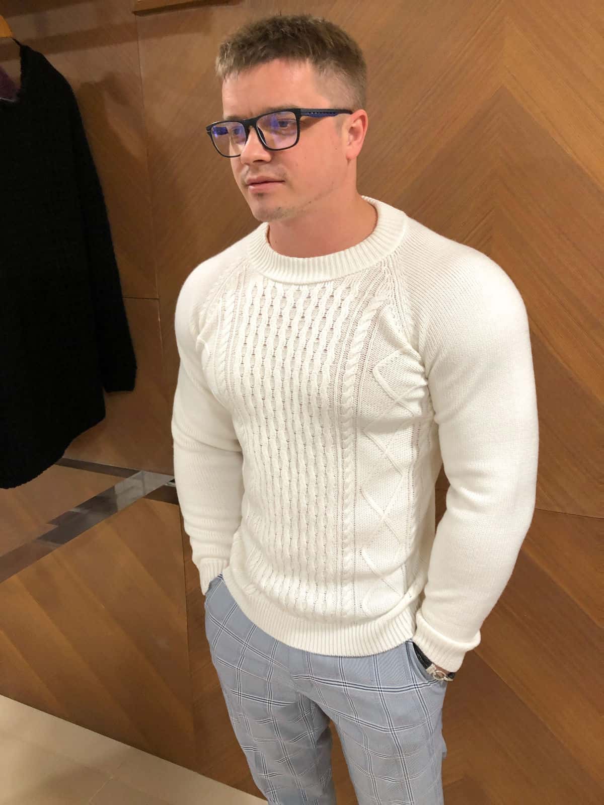 На фотографии мужской свитер белый с косами от Shapar, бренда вязаной одежды ручной работы в интернет-магазине связанных спицами вещей.