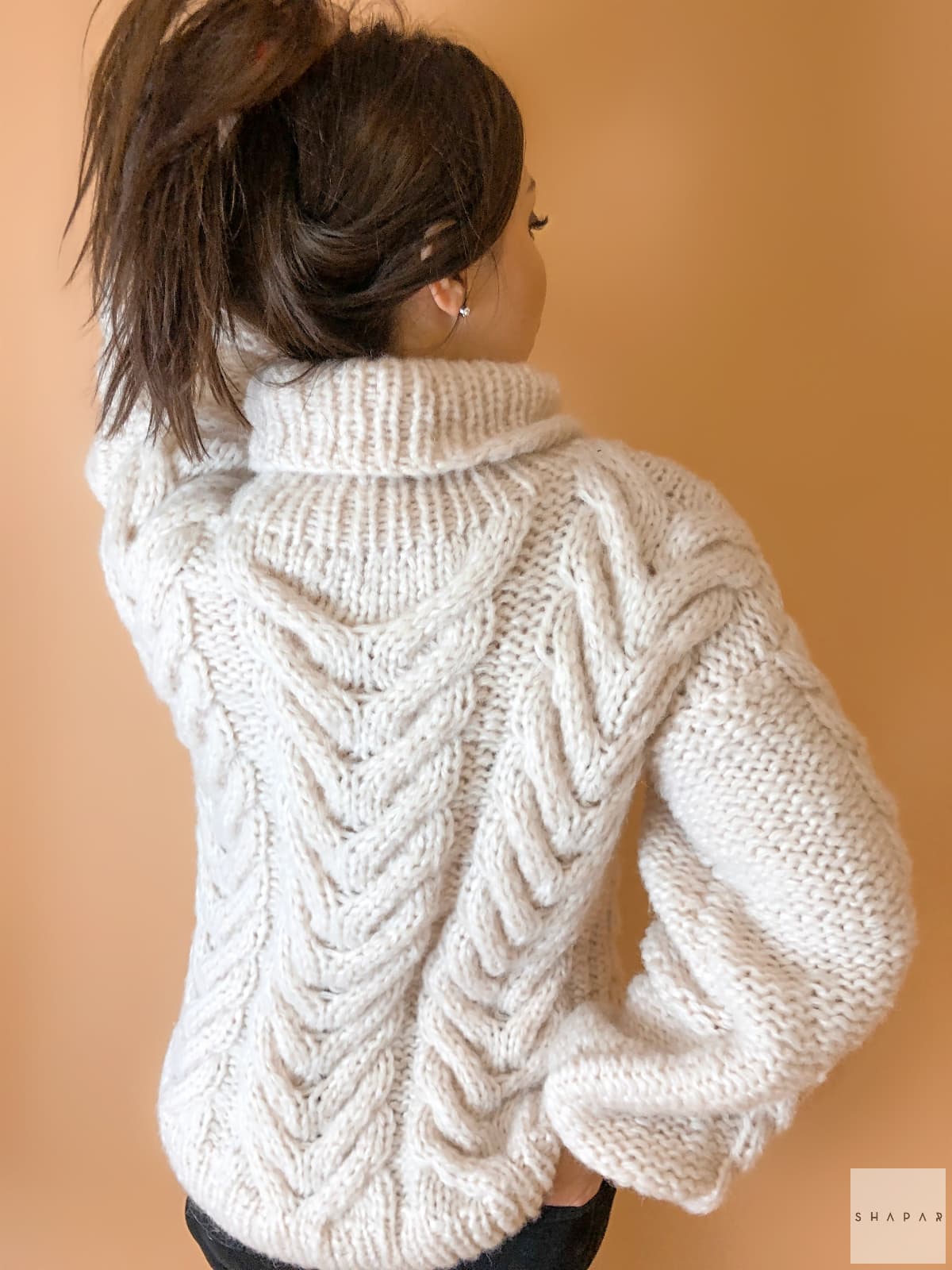 На второй фотографии женский свитер с аранами со спины от Shapar, бренда вязаной одежды ручной работы в интернет-магазине связанных спицами вещей.