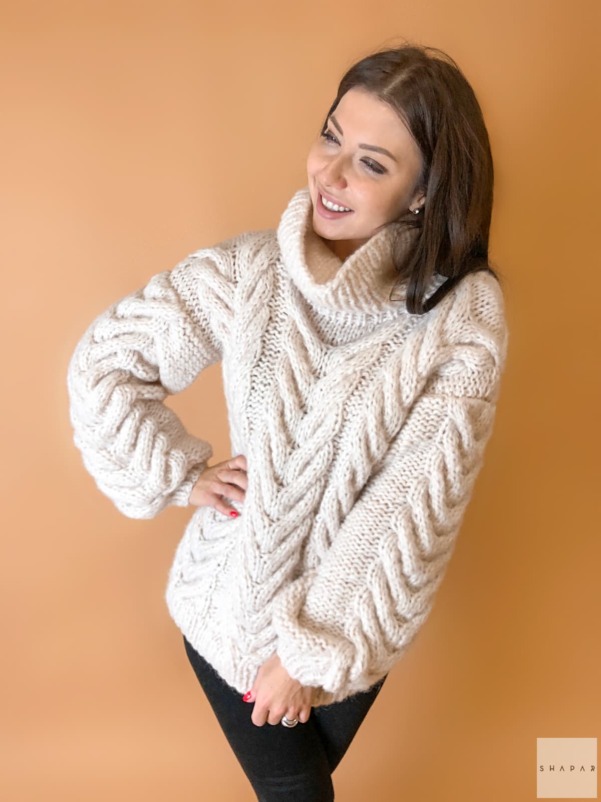 На фотографии женский свитер с аранами от Shapar, бренда вязаной одежды ручной работы в интернет-магазине связанных спицами вещей.