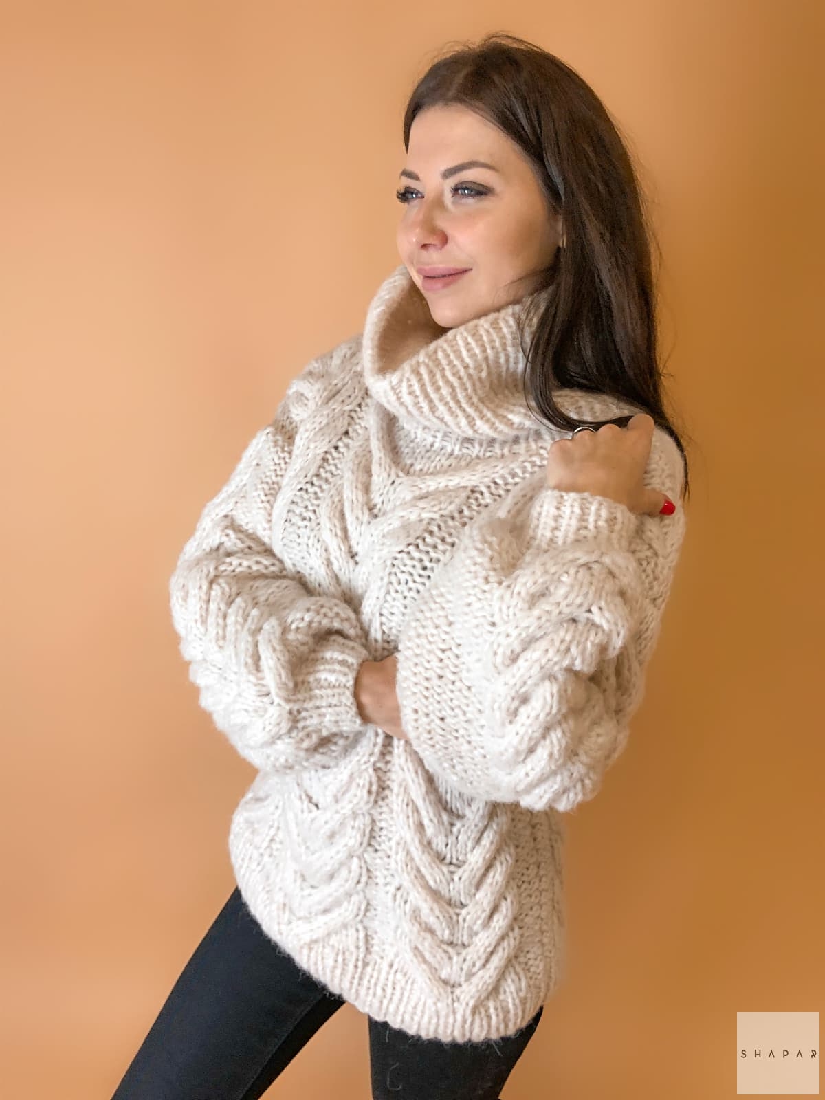 На третьей фотографии женский свитер с аранами бежевого цвета от Shapar, бренда вязаной одежды ручной работы в интернет-магазине связанных спицами вещей.