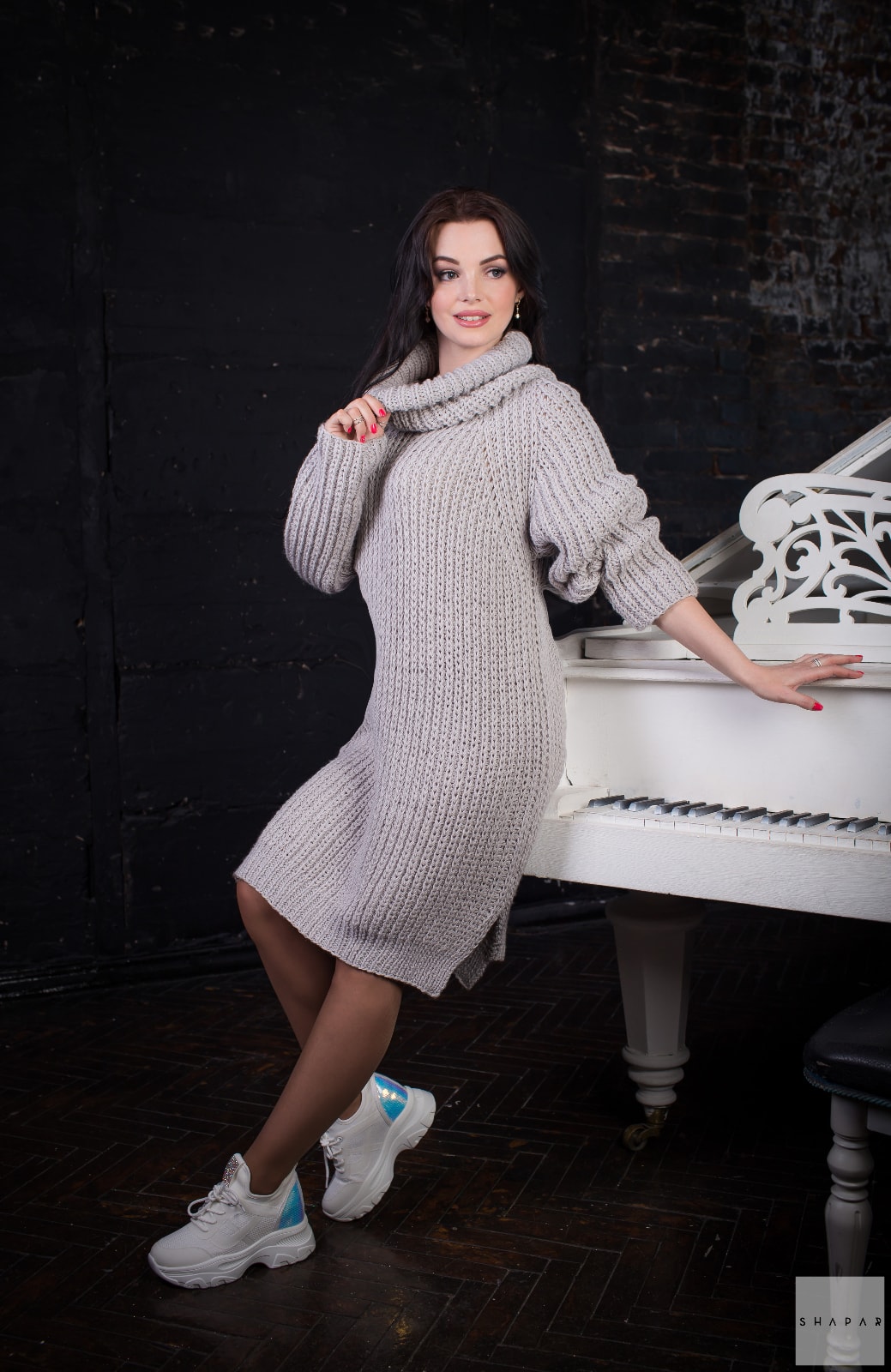 На фотографии длинный свитер женский крупной вязки от Shapar, бренда вязаной одежды ручной работы в интернет-магазине связанных спицами вещей.