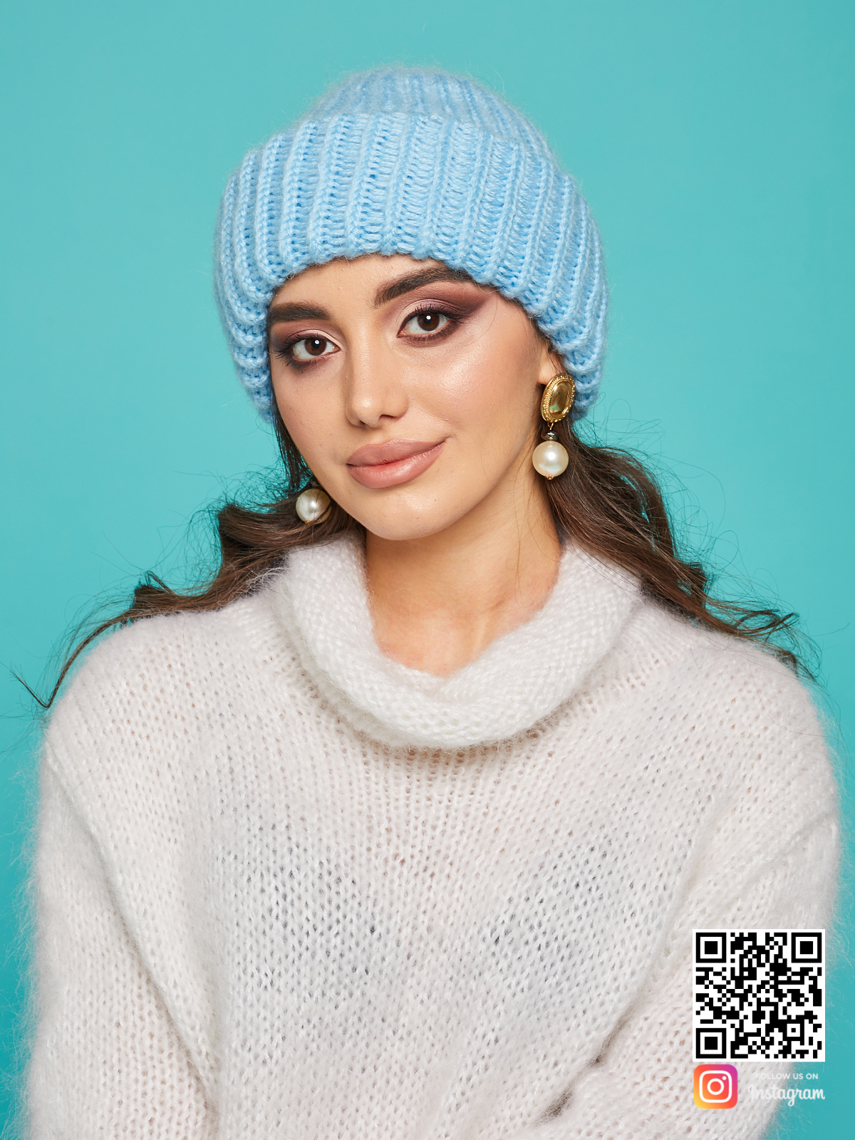 На фотографии голубая вязаная шапка от Shapar, бренда одежды и головных уборов ручной работы в интернет-магазине связанных спицами вещей.
