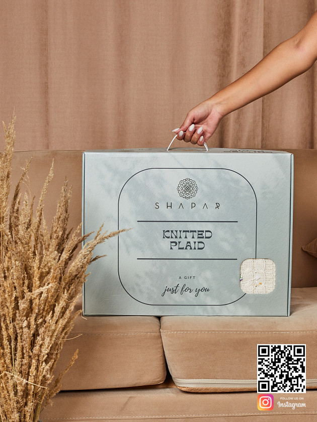 На второй фотографии плед с косами в подарочной упаковке в интернет-магазине Shapar, бренда трикотажа и связанной одежды ручной работы.