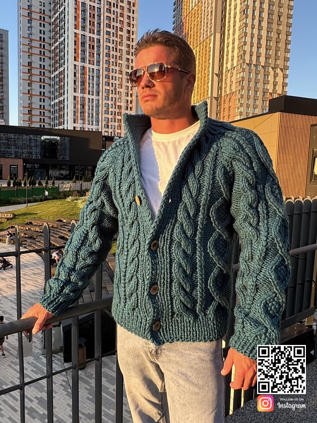 На фотографии мужской кардиган с объемными косами от Shapar бренда вязаной одежды ручной работы в интернет-магазине связанных спицами вещей.